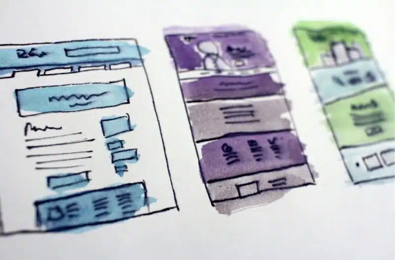 three different draws of a website layout on paper